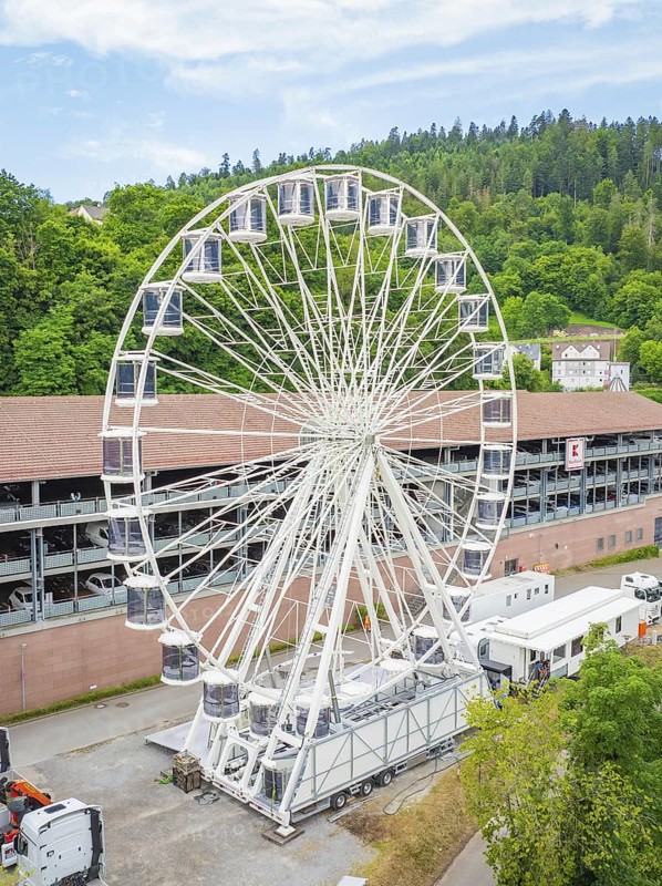 Large Ferris wheel in front of wooded hills and buildings, construction of Ferris wheel, Calw, Black Forest, Germany