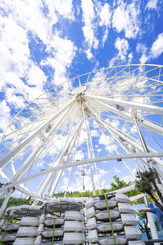 Partially erected Ferris wheel in front of a clear blue sky with cloud formations, Ferris wheel construction for the 950th anniversary of the city of Calw, Black Forest, Germany
