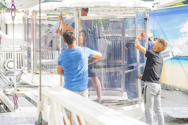 People working on a glass cabin of a Ferris wheel in an amusement park, Ferris wheel construction for the 950th anniversary of the town of Calw, Black Forest, Germany