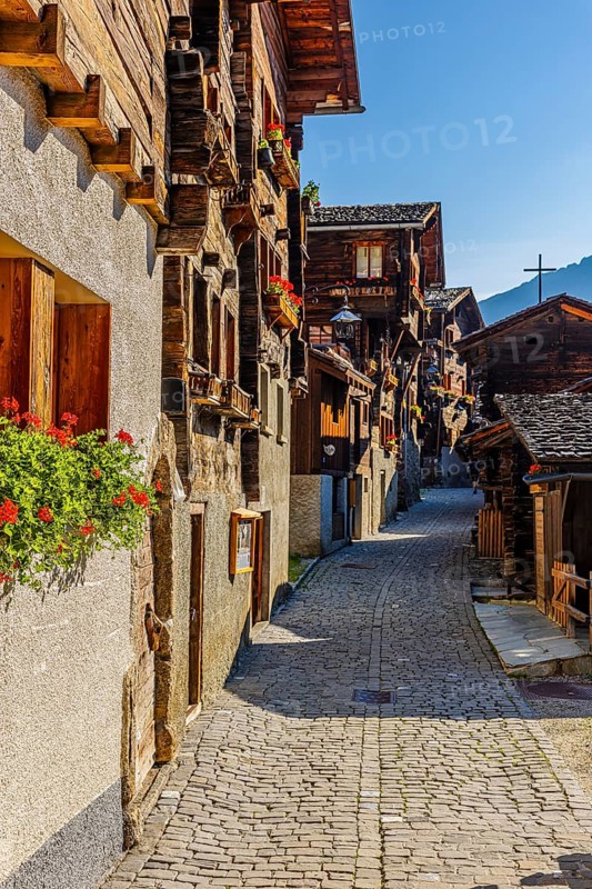 Old wooden houses decorated with flowers, in the village street, historic village centre, Grimentz, Val d'Anniviers, Valais Alps, Canton Valais, Switzerland