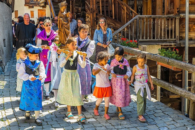 Women and children carrying the statue of the Virgin Mary with the Infant Jesus in the Corpus Christi procession, historic town centre, Grimentz, Val d'Anniviers, Valais Alps, Canton Valais, Switzerland