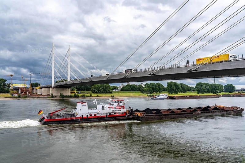 Rhine bridge Duisburg-Neuenkamp, the A40 motorway, start of construction of the second bridge, bridge piers and the first bridge segment are erected on the Neuenkamp side of the Rhine, cargo ship on the Rhine, push boat Herkules II, push convoy, with coal for the HKM coking plant in Duisburg, North Rhine-Westphalia, Germany
