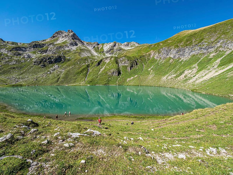 Hiker at lake Engeratsgundsee, mountain range between Oberstdorf and Bad Hindelang, Allgaeu, Bavaria, Germany