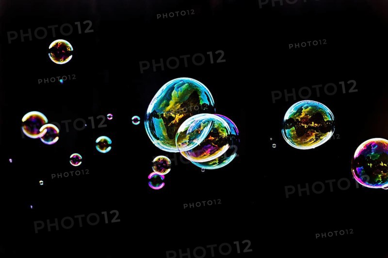 Iridescent soap bubbles in the colours of the rainbow against a black background, Recklinghausen, North Rhine-Westphalia, Germany