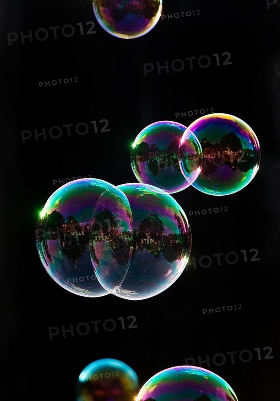 Iridescent soap bubbles in the colours of the rainbow against a black background, Recklinghausen, North Rhine-Westphalia, Germany