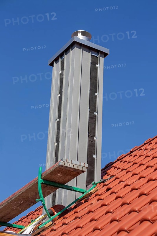 Chimney with high-quality titanium zinc cladding on a straight tiled roof