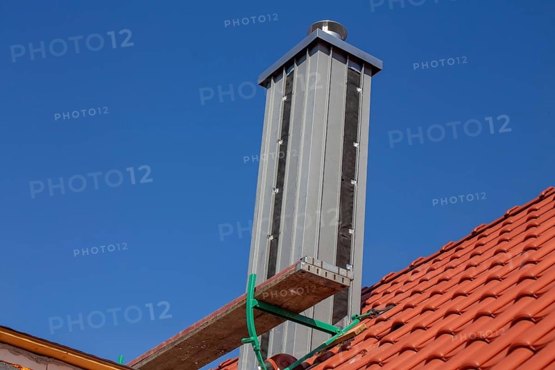 Chimney with high-quality titanium zinc cladding on a straight tiled roof