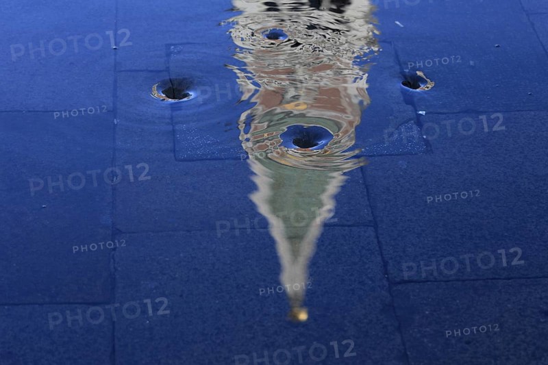 Reflection of the Campanile with water vortex of the flowing flood water, Acqua alta, Venice, Veneto, Italy