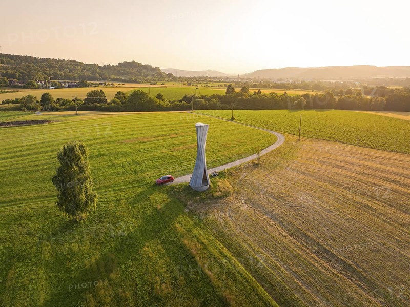 Panorama of a green landscape with a modern observation tower in the sun