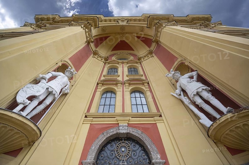 Main façade with two sculptures, the giant Haymon and his opponent the giant Thyrsus, legendary figure at the entrance portal of Wilten Abbey, Klostergasse 7, Wilten, Innsbruck, Austria