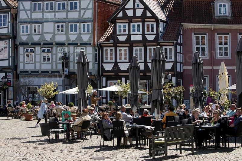 People in the outdoor catering area in the old town with many half-timbered houses, Großer Plan, Celle, Lower Saxony, Germany