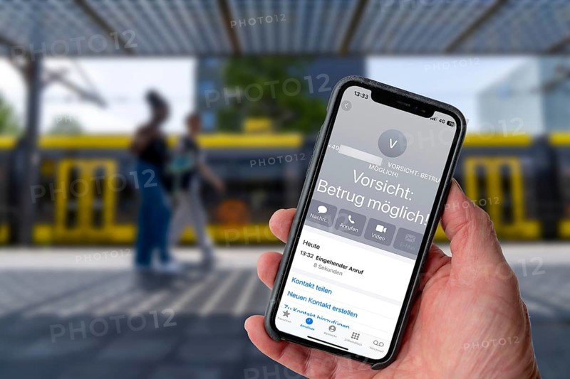 Symbolic image of mobile phone scam, warning of fraudulent calls, here the provider Vodafone, warns the mobile phone user that the caller may have a suspicious number that suggests fraud, spam protection system, the caller's number is stored in a database in which suspicious spam callers are stored, prevention of fraud attempts via mobile phone