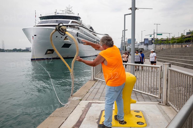 Detroit, Michigan - The Viking Octantis luxury cruise ship in Detroit on a cruise through the Great Lakes. A Port of Detroit worker removes mooring lines as the ship prepares to depart