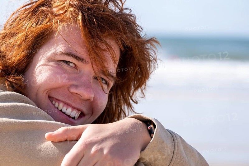 Young man with red hair, sitting on the beach, Jeffreys Bay near Port Elizabeth, Garden Route, Eastern Cape, South Africa