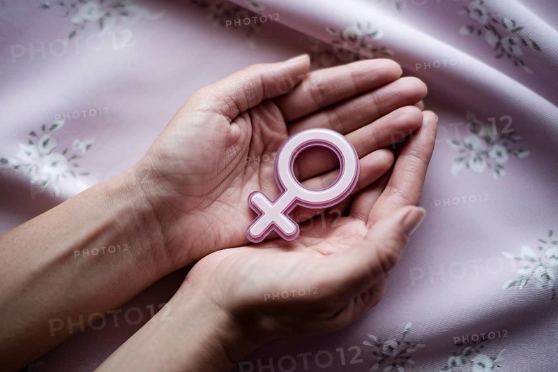 Woman's hands cradling glossy female gender symbol. A visual tribute to strength, femininity, and resilience. Generative ai, AI generated