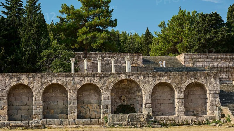 Wide angle view of ancient ruins and stone arches with dense forest in the background, retaining wall with arcades, Asklipion, Asklepieion, healing temple, temple, Hippocrates, Kos, Dodecanese, Greek Islands, Greece