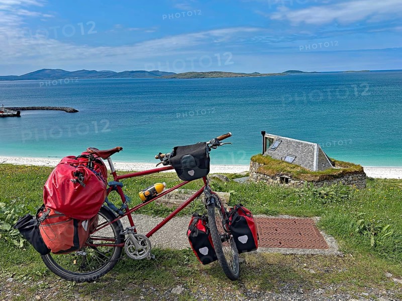Luggage-laden bicycle in front of turquoise sea and blue sky on a rocky coastal landscape, cycle tourism, travelling, bicycle tour, Eriksay, Hebrides, Scotland, Great Britain