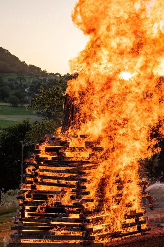 Sunset at a midsummer fire in Germany, Swabian Alb, Lenninger Tal, June 2025, firefighter in the background
