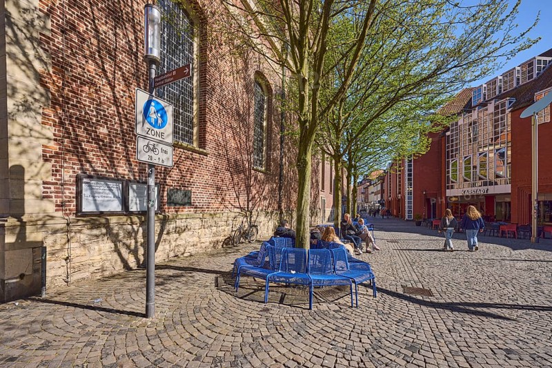 Pedestrian zone, traffic sign, benches, trees, brick building, facade, seated persons as secondary motif, blue cloudless sky, Salzstraße, Münster, Münsterland, independent city, North Rhine-Westphalia, Germany