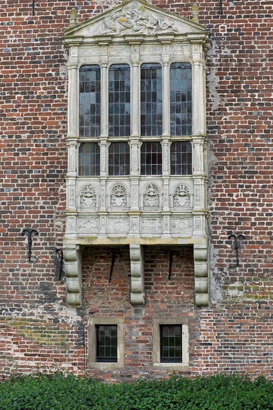 A richly decorated Gothic bay window on an old brick wall, Raesfeld moated castle, Münsterland, North Rhine-Westphalia, Germany