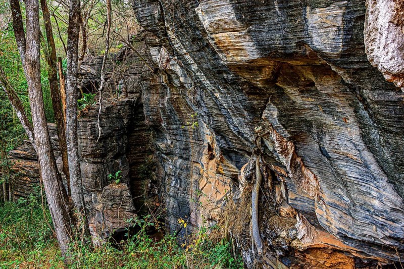 Vertical rocky formation between the trees of the tropical forest in Lapinha da Serra, Minas Gerais, Lapinha da Serra, Minas Gerais, Brazil