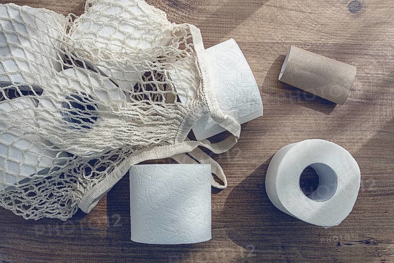 Mesh bag on the table, with rolls of toilet paper, top view, no people