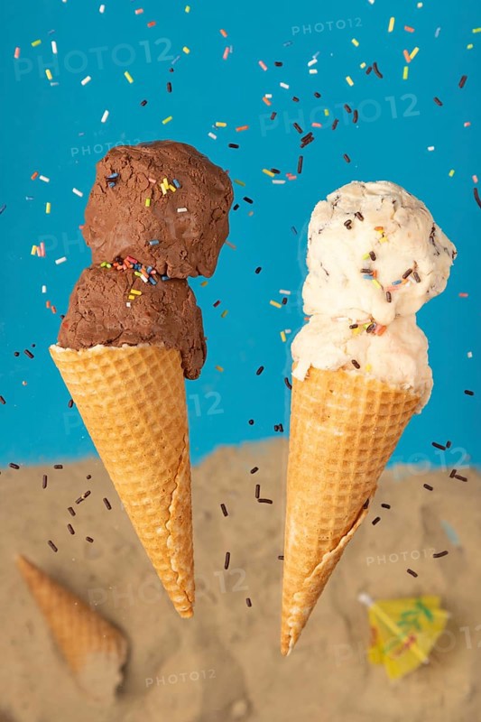 Chocolate and vanilla ice cream in wafers against a blue background with sprinkles