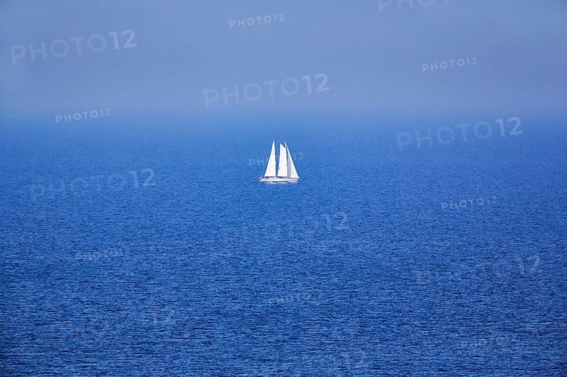 Blue sea, calm water surface, single sailing boat on the horizon, haze, offshore island Helgoland, Schleswig-Holstein, Germany
