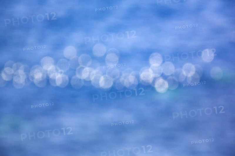 White light reflections, bokehballs on blue sea, water surface, Germany