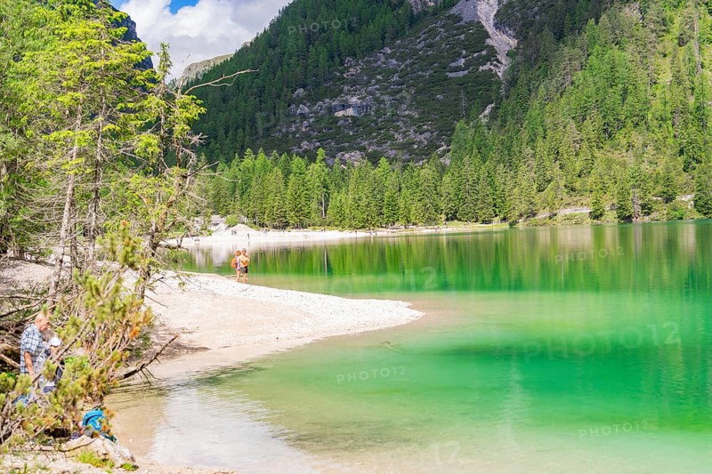 Peaceful landscape with lake and beach, surrounded by forest and mountains, Pragser Wildsee, South Tyrol, Dolomites, Italy