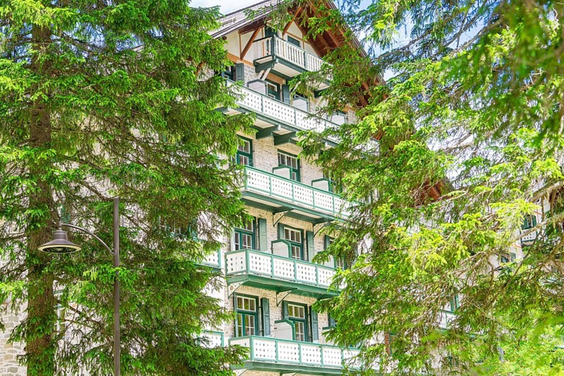 A hotel building with green trees and balconies in a wooded setting, Lake Braies, South Tyrol, Dolomites, Italy