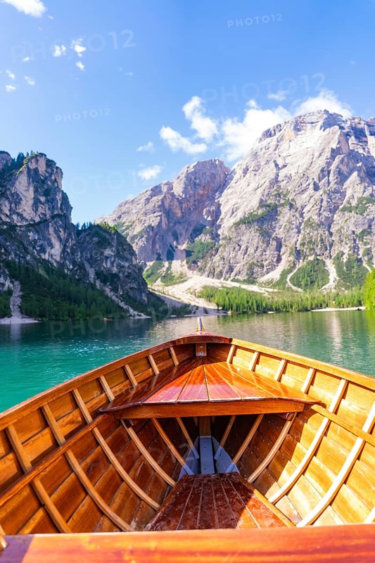 Perspective from the boat towards the majestic mountain landscape over clear water, Pragser Wildsee, South Tyrol, Dolomites, Italy