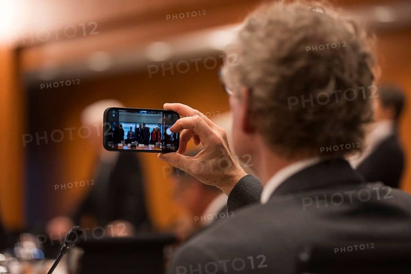 A person takes a photo with their mobile phone in front of the meeting of Federal Chancellor Friedrich Merz with the heads of government of the federal states in the International Conference Hall of the Federal Chancellery, Berlin, 18 June 2025