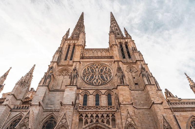 Low angle view of the facade of st. Andrew's cathedral, highlighting its intricate gothic architecture and towering spires against a cloudy sky