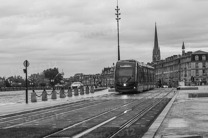 Sleek, modern tram is passing through a bordeaux cityscape, showcasing the city's blend of historical and contemporary architecture