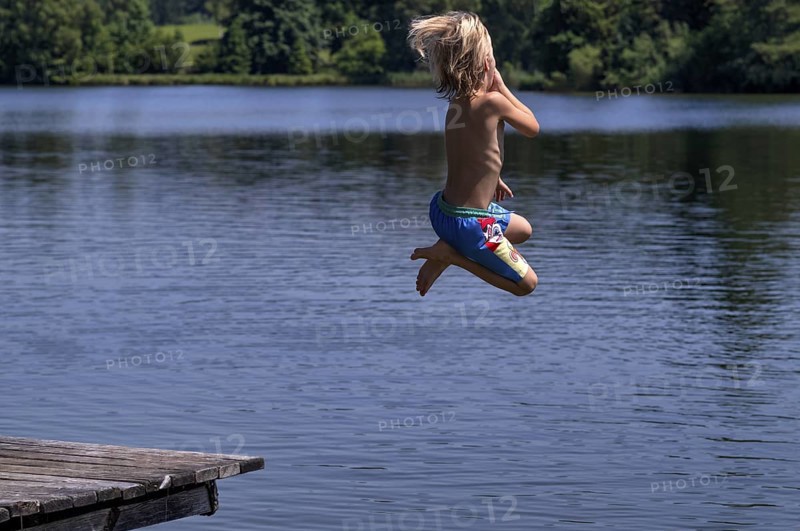 Boy, 6 years, blond, jumping from wooden footbridge, footbridge into the water, bathing lake, lake, Schwaltenweiher near Seeg, Ostallgäu, Allgäu, Swabia, Bavaria, Germany