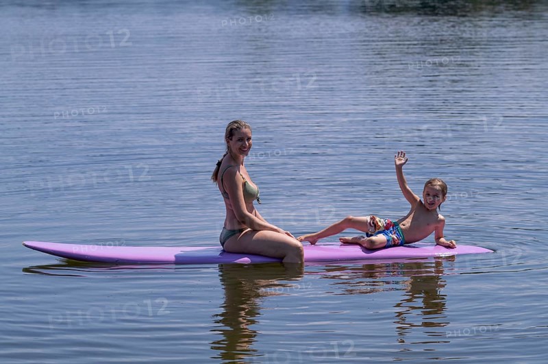 Mother, woman, blonde, in bikini and son, boy, 6 years, sitting on board, waving, surfboard, surfboard, purple, back, from behind, relaxed, bathing lake, lake, Schwaltenweiher near Seeg, Ostallgäu, Allgäu, Swabia, Bavaria, Germany