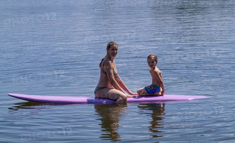 Mother, woman, blonde, in bikini and son, boy, 6 years, sitting on board, surfboard, surfboard, violet, back, from behind, relaxed, bathing lake, lake, Schwaltenweiher near Seeg, Ostallgäu, Allgäu, Swabia, Bavaria, Germany