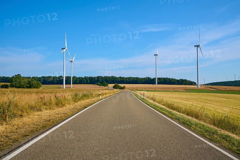 A road leads through fields, flanked by several wind turbines under a clear sky, summer, Wenkheim, Werbach, Baden-Württemberg, Germany