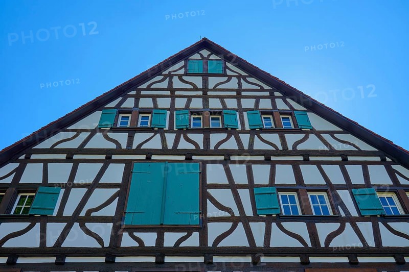 Gable facade of a half-timbered house with green shutters against a blue sky, Triberg im Schwarzwald, Schwarzwald-Baar-Kreis, Black Forest, Baden-Württemberg, Germany
