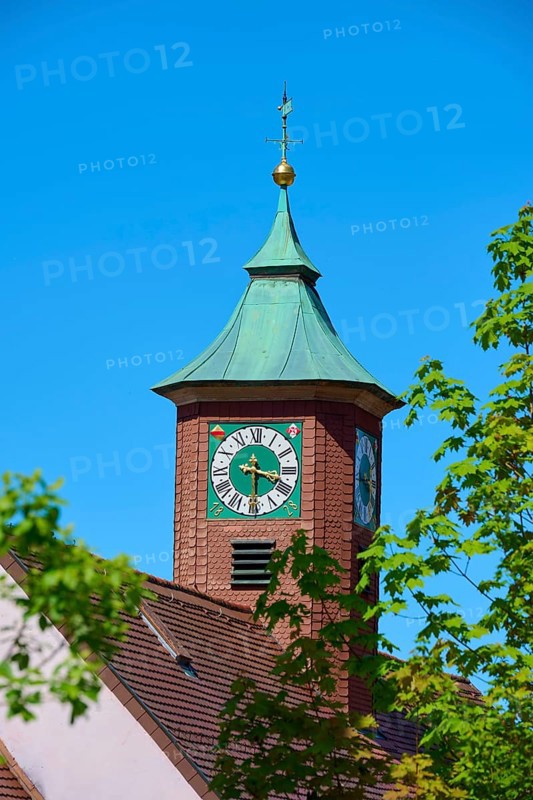 A tower with a green dome and clock, surrounded by blossoming trees under a clear sky, Triberg in the Black Forest, Black Forest-Baar district, Black Forest, Baden-Württemberg, Germany