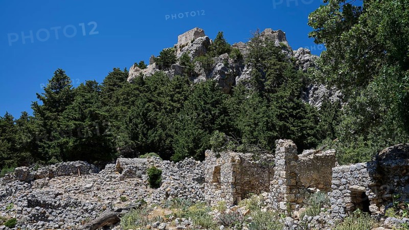 Ancient ruins in front of a wooded hill with clear blue sky in the background, Abandoned Village, Lost Place, Pyli, Paleo Pyli, Byzantine Fortress, Kos, Dodecanese, Greek Islands, Greece