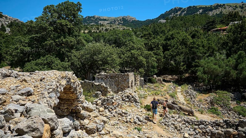 Two people explore ancient ruins surrounded by mountains and forests, Abandoned Village, Lost Place, Pyli, Paleo Pyli, Byzantine Fortress, Kos, Dodecanese, Greek Islands, Greece
