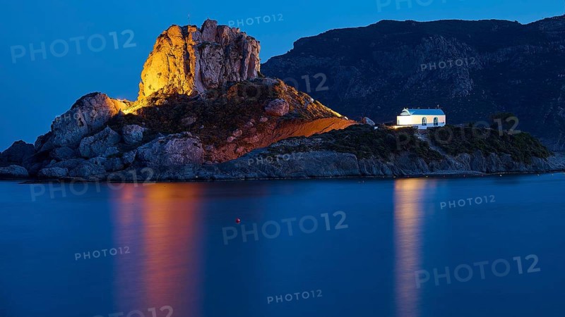 An idyllic night view of an illuminated island with a chapel and calm sea, Agios Stefanos Beach, Agios Stefanos Basilica, Agios Nikolaos Chapel, Kastri Island, Kos, Dodecanese, Greek Islands, Greece