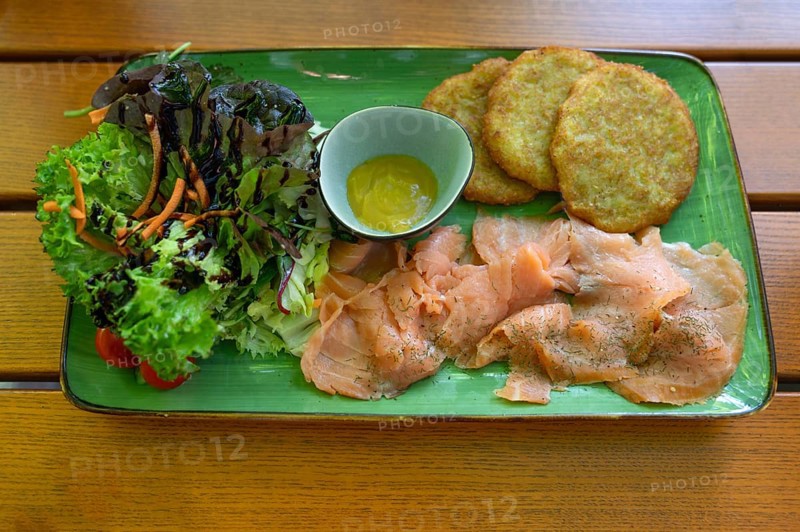 Salmon with baggers, potato pancakes and salad, served in a beer garden, Franconia, Bavaria, Germany