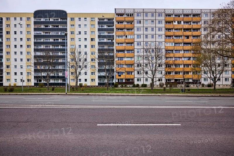 Residential building, high-rise buildings, facade, window, balcony, bare wintry trees, lantern, road surface, asphalt, lane markings, diffuse light, cloudy, Ebendorfer Chaussee, Magdeburg, state capital, independent city, Saxony-Anhalt, Germany