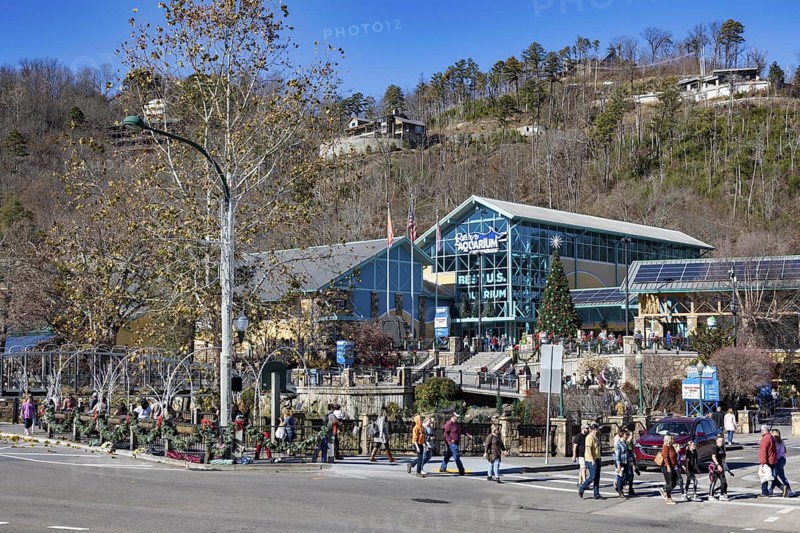 Tourists walking past Ripley's Aquarium of the Smokies on street decorated for the Christmas holiday in Gatlinburg, Tennessee