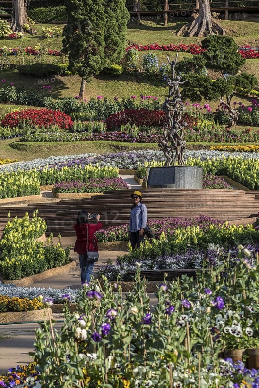 Women taking photographs at the Continuity statue in Mae Fah Luang Gardens within the Doi Tung tourist attraction in Chiang Rai, Thailand
