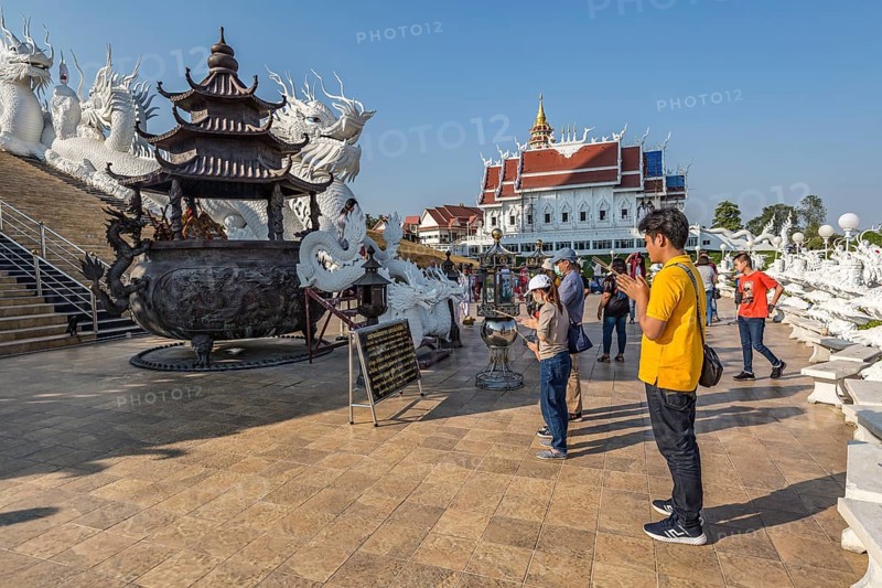 Visitors make a wai phra offering to Buddah in front of the Guan Yin (Goddess of Mercy) statue at Wat Huay Pla Kang Temple in Chiang Rai province of Northern Thailand