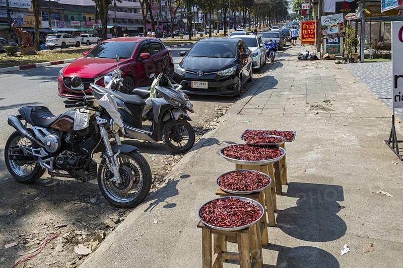 Trays of peppers on the sidewalk for sale along Ban Du street in Chiang Rai, Thailand